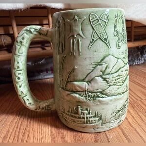 Vintage handcrafted ceramic souvenir mug featuring a raised relief map of Alaska